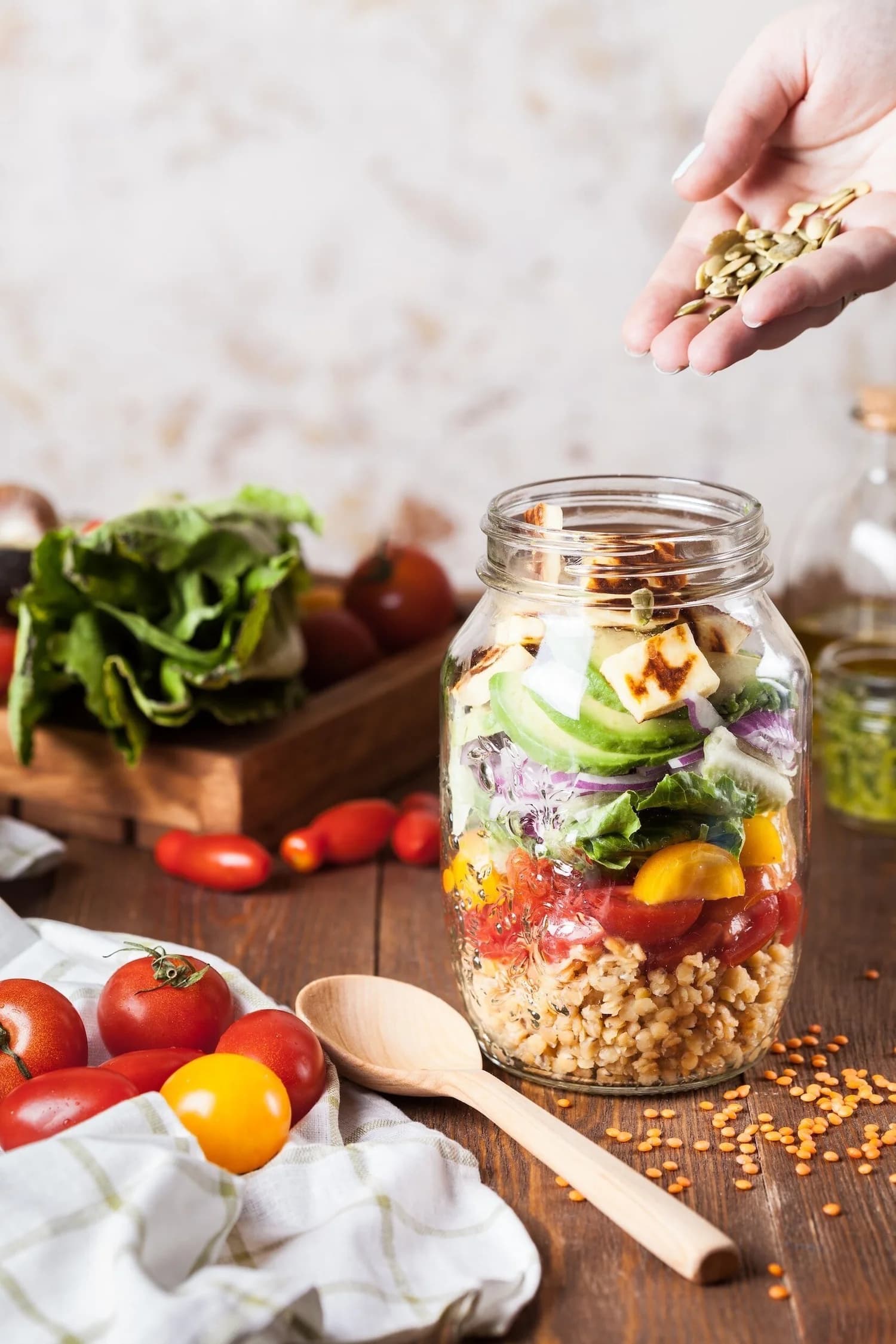A jar of layered whole foods — grains, tomatoes, greens and avocado — for the 5-Day Reset
